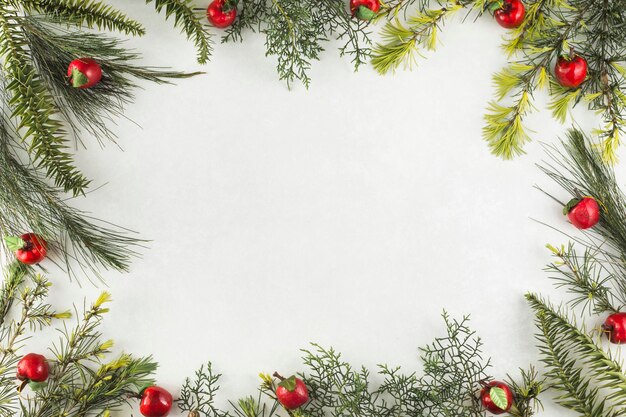 Composición navideña de ramas con manzanas rojas.