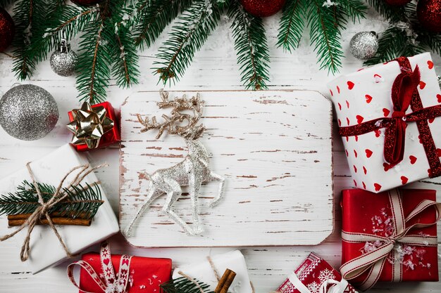Composición navideña de tablero de madera con ciervo pequeño.