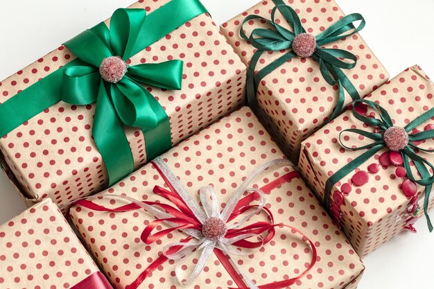 Composición navideña de varias cajas de regalo envueltas en papel artesanal y decoradas con cintas de raso. Vista superior, endecha plana.