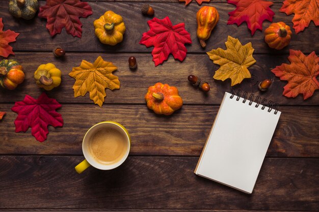 Composición de otoño con bloc de notas y café