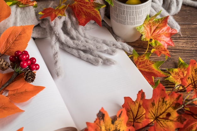 Foto gratuita composición de otoño con libro abierto sobre la mesa