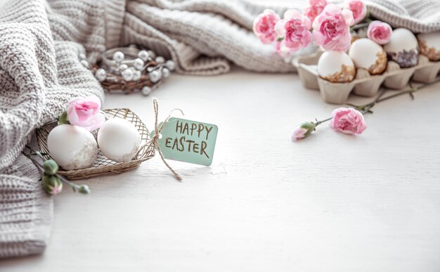 Composición de Pascua festiva con huevos, flores y la inscripción Feliz Pascua copia espacio.