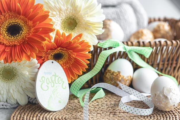 Foto gratuita composición de pascua con flores de gerbera y huevos decorativos en una canasta