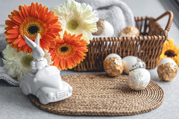 Composición de Pascua con flores y huevos de gerbera de liebre de cerámica