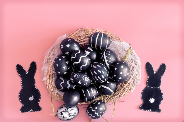 Composición de Pascua con huevos y el conejito de Pascua en una mesa rosa