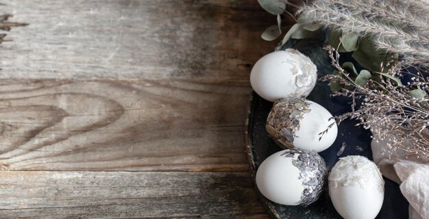 Composición de Pascua con huevos decorativos en un espacio de copia de superficie de madera.