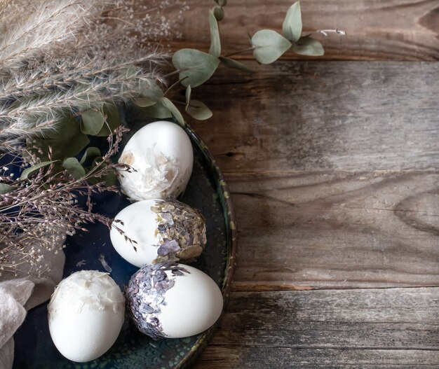 Composición de Pascua con huevos decorativos en un espacio de copia de superficie de madera.