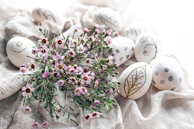 Composición de pascua con huevos y flores pintados a mano.