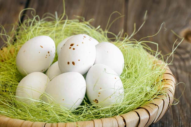 Composición de pascua con huevos en un nido decorativo.