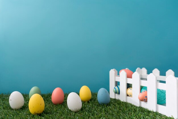 Composición de pascua con valla de madera y huevos decorativos