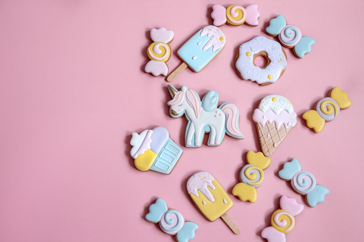Foto gratuito composición plana con galletas de jengibre glaseadas brillantes sobre fondo rosa.