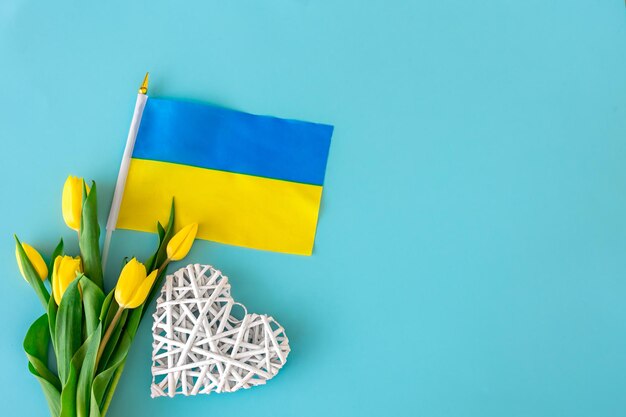 Composición plana con un ramo de tulipanes amarillos, la bandera de ucrania
