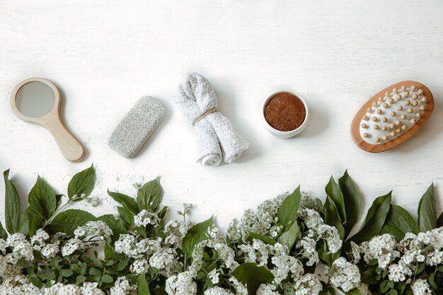 Composición plana de spa con accesorios de baño, productos de salud y belleza con flores frescas.