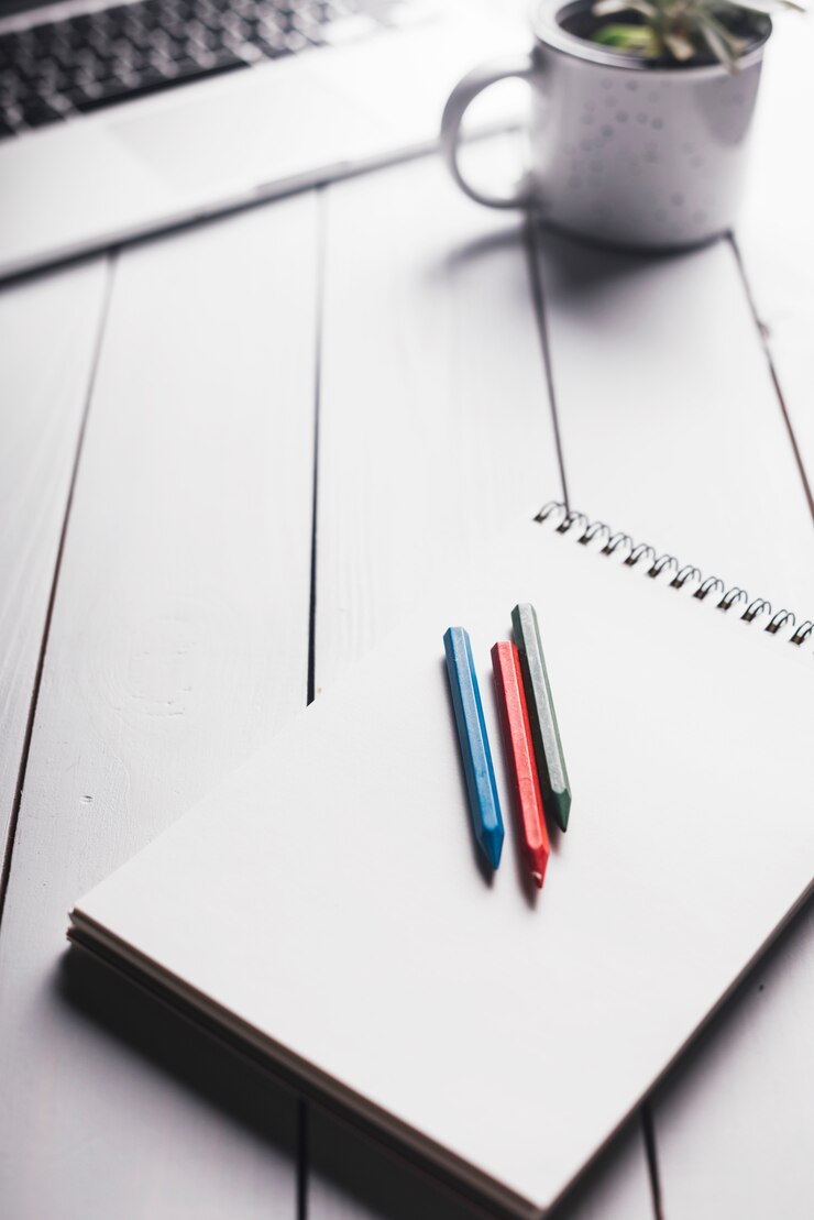 Foto gratuito composición de portátil y libreta en escritorio