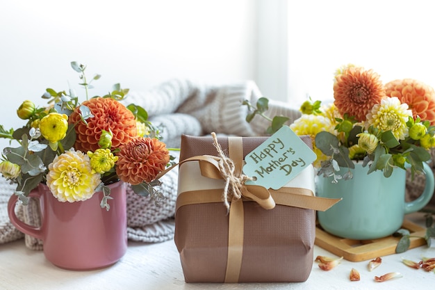 Composición de primavera para el día de la madre con un regalo y flores de crisantemo.