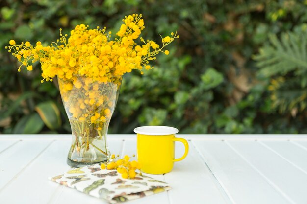 Composición de primavera con flores, taza y cuaderno