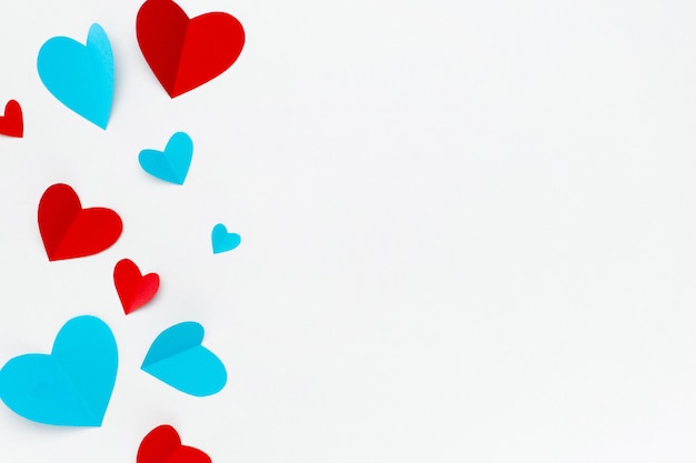 Composición romántica hecha con corazones rojos sobre fondo blanco con copyspace para texto