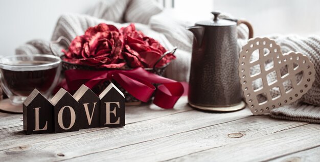 Una composición romántica para San Valentín con la palabra decorativa amor y detalles decorativos.