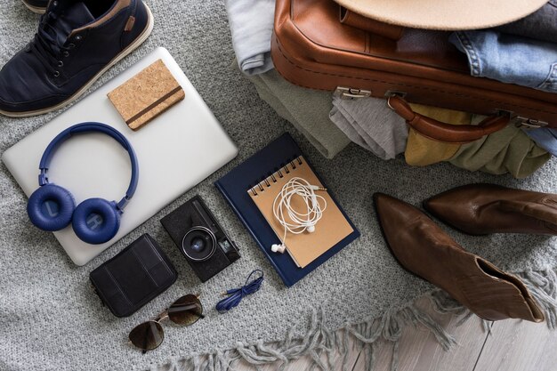 Composición de ropa y accesorios en una maleta.