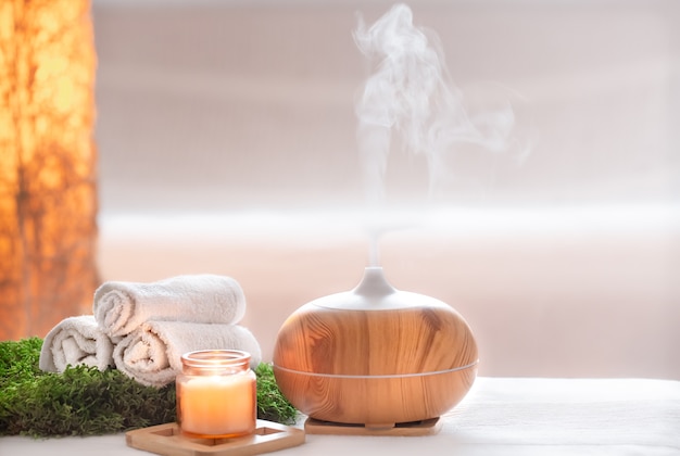 Composición de spa con aroma de moderno difusor de aceite con productos para el cuidado corporal.