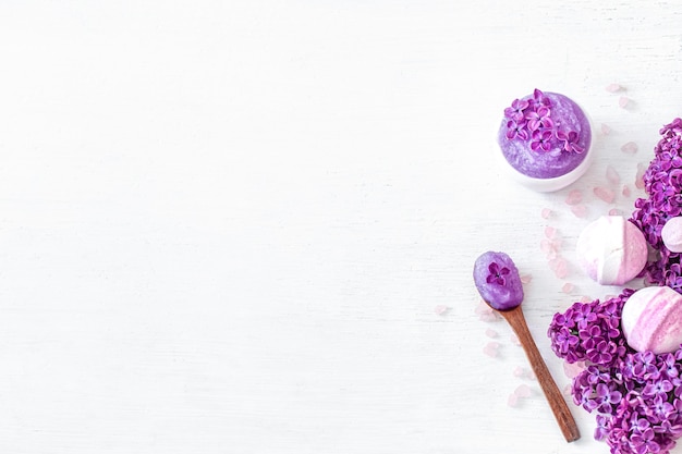 Composición de Spa de fondo para el cuidado del cuerpo sobre un fondo de madera clara con flores lilas. Belleza y cuidado corporal. Concepto de spa.