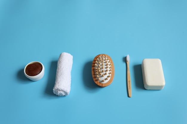 Composición de spa minimalista con jabón, cepillo de dientes, cepillo de masaje, exfoliante y toalla, concepto de higiene personal.