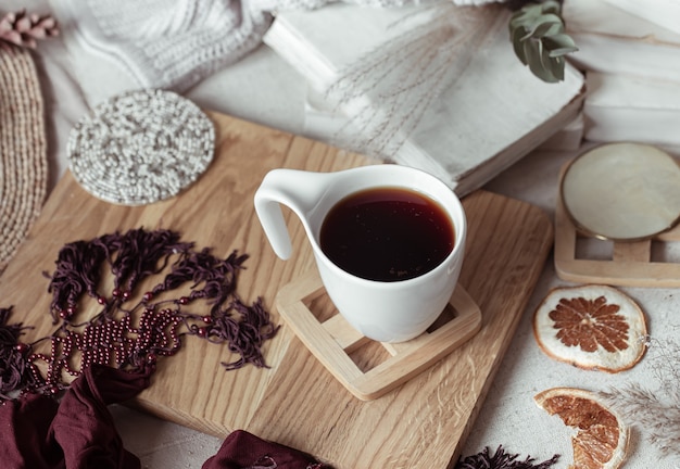 Composición con una taza de bebida caliente entre bellas cositas. Concepto de confort en el hogar.