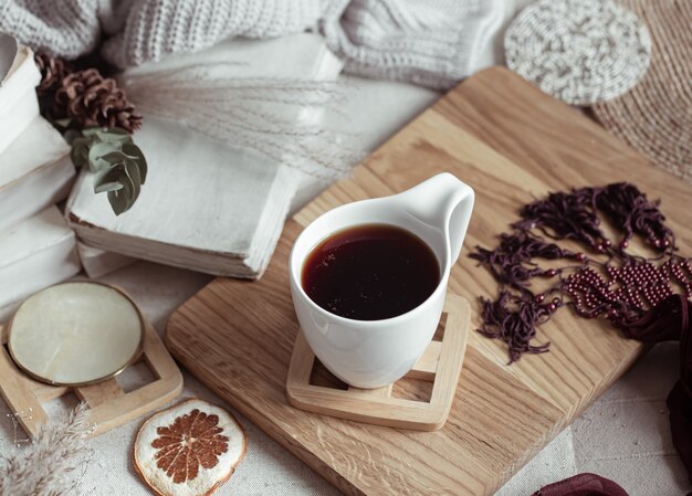 Composición con una taza de bebida caliente entre bellas cositas. Concepto de confort en el hogar.