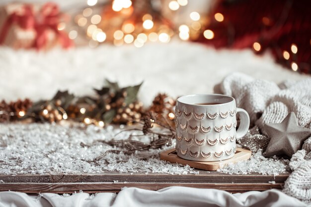 Composición con taza de Navidad con bebida caliente en el espacio de copia de fondo abstracto borroso.