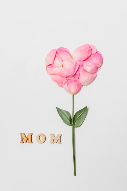 Composición del título de mamá cerca de la floración rosa en forma de corazón
