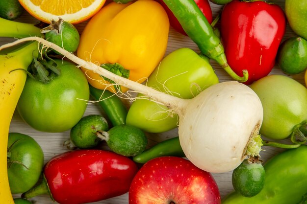 Composición vegetal de la vista superior con frutas en el escritorio blanco