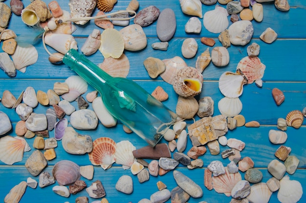 Composición veraniega con botella y conchas marinas