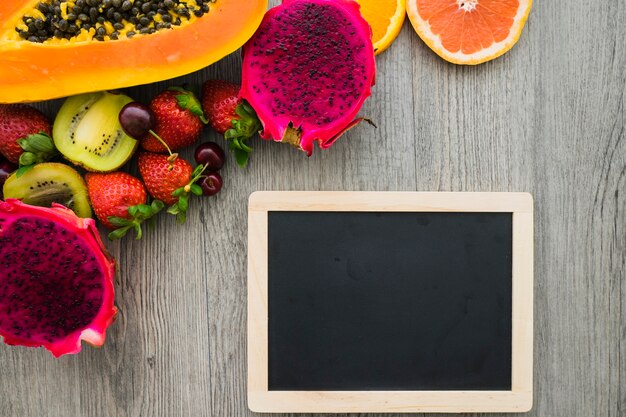 Composición veraniega con frutas y pizarra en blanco