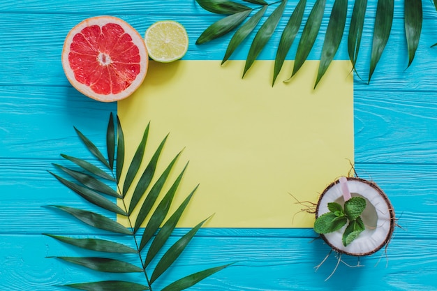 Composición veraniega con papel amarillo y frutas decorativas