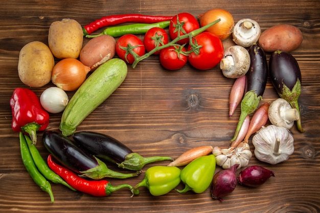 Composición de verduras frescas de vista superior en escritorio marrón