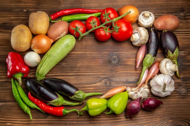 Composición de verduras frescas de vista superior en escritorio marrón