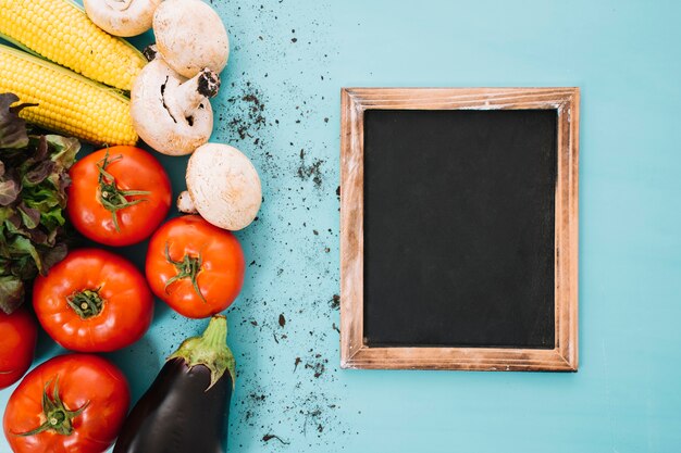 Composición de verduras con pizarra a la derecha