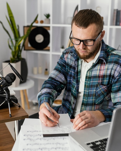 Compositor de tiro medio escribiendo en un portátil