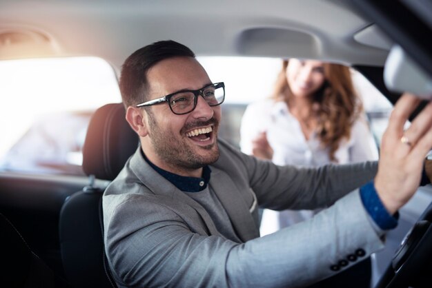 Comprador de automóviles que le gusta el interior del vehículo nuevo en el concesionario de vehículos