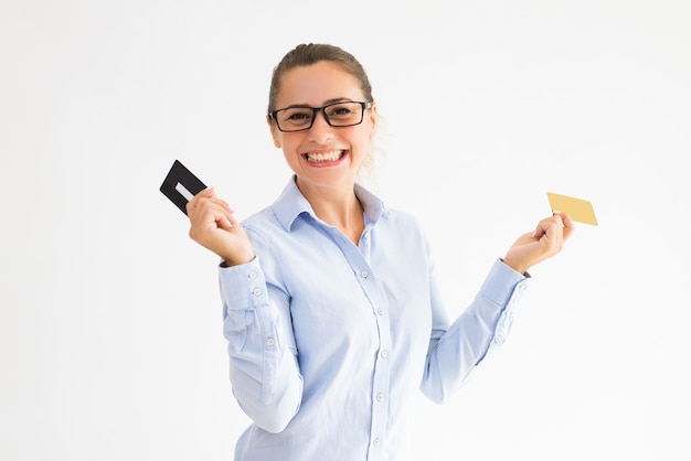 Comprador femenino positivo que sostiene varias tarjetas de lealtad