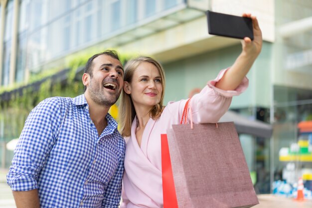 Comprador personal exitoso que toma el autorretrato con el cliente feliz.