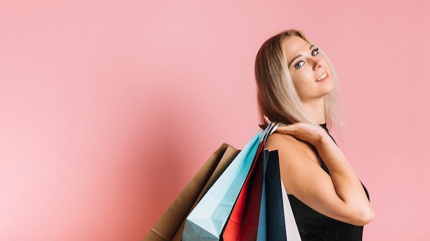 Comprador sonriente con bolsas de colores.