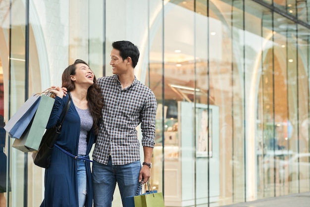 Compradores felices riendo sin preocupaciones en un centro comercial