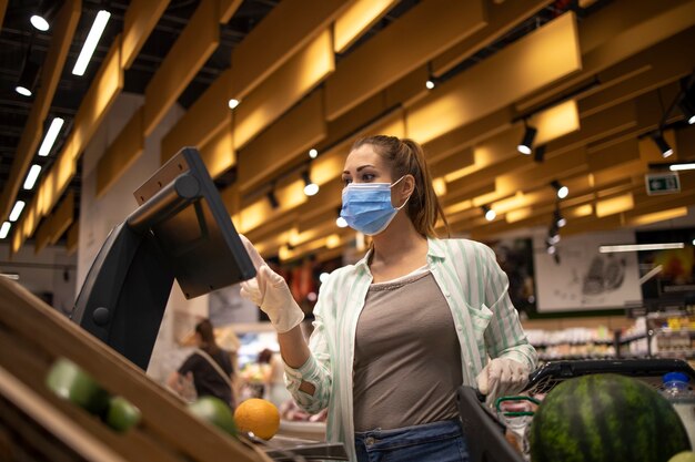 Comprar alimentos en un supermercado durante la pandemia mundial del virus corona