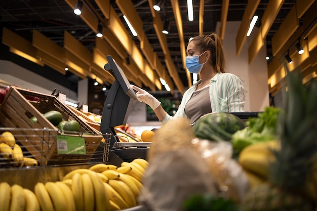 Comprar alimentos en un supermercado durante la pandemia mundial del virus corona