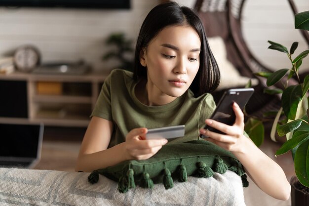 Compras en línea mujer asiática compra compras en línea en la aplicación en el teléfono móvil usando el coche de crédito ...