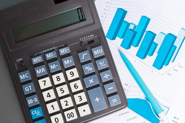 Comprobación del informe contable en la mesa de negocios. Calculadora