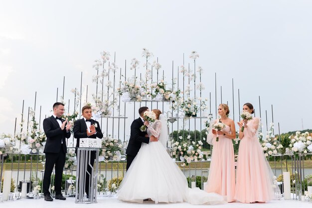 Compromiso de la novia con el novio en la ceremonia al aire libre con amigos