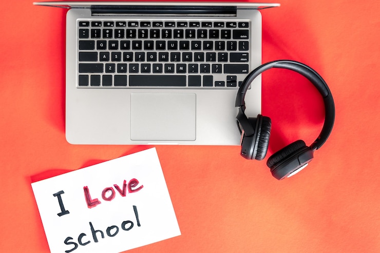 Foto gratuito computadora portátil y auriculares sobre fondo rojo amor concepto de escuela
