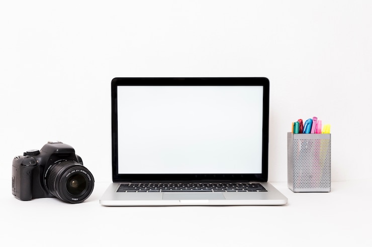 Foto gratuito computadora portátil y cámara modernas en el fondo blanco